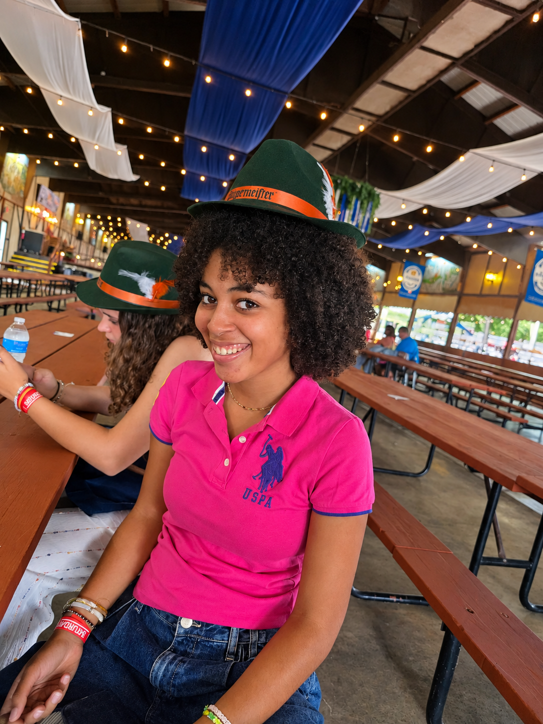 Marie smiling in a green feathered hat at the Bavarian Bierhaus Oktoberfest in Glendale, Wisconsin.